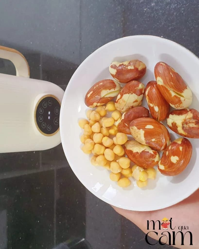 Đĩa hạt mít đã luộc và đậu gà, bên cạnh là máy làm sữa hạt